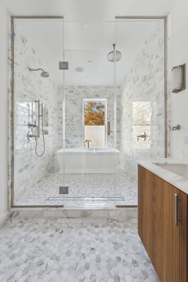 full bath with a soaking tub, a marble finish shower, and vanity