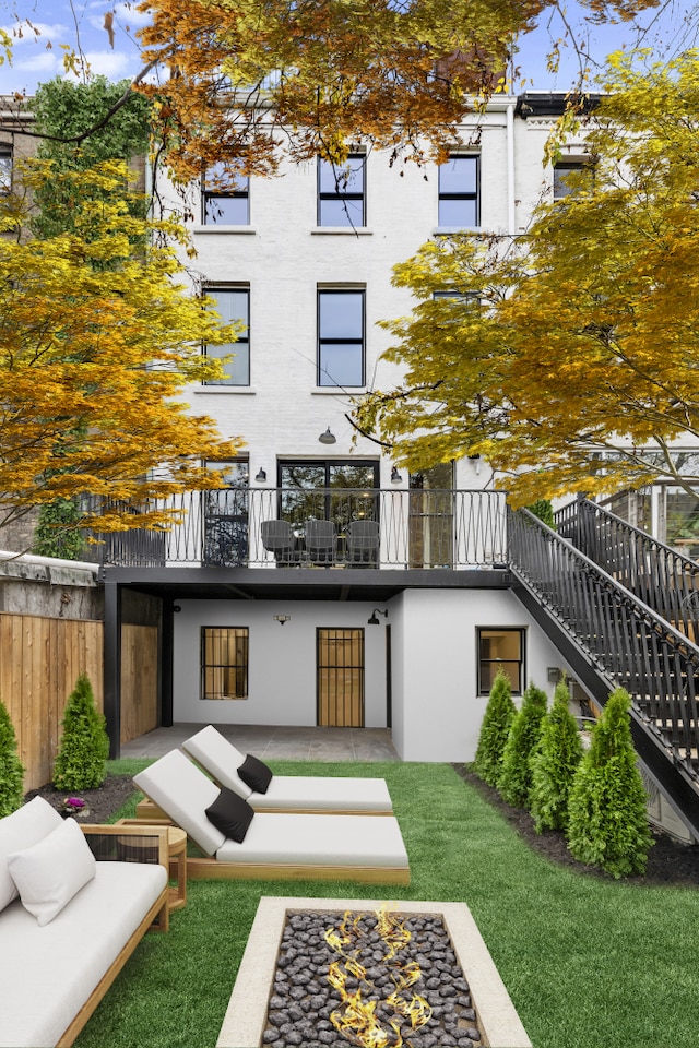 back of house with a yard, a patio, stairway, a balcony, and an outdoor living space