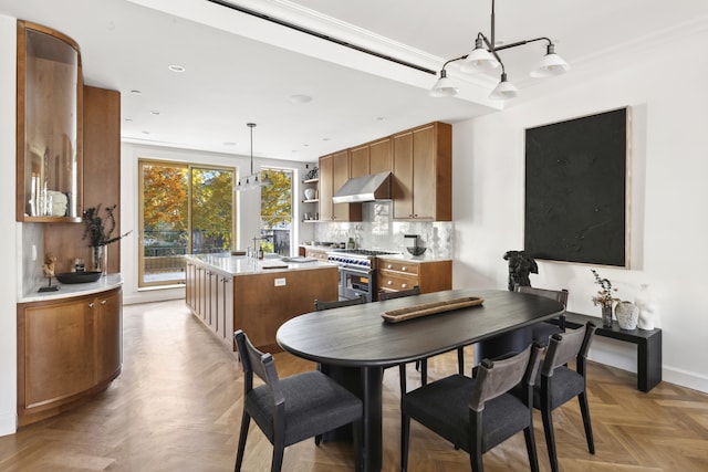 kitchen featuring stainless steel range, a kitchen island with sink, ventilation hood, light countertops, and open shelves