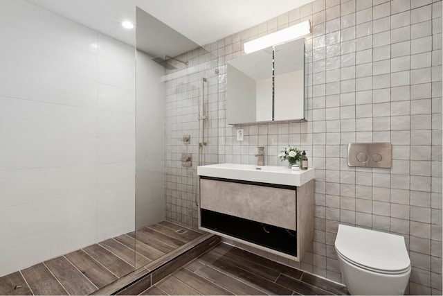 full bath with vanity, wood tiled floor, walk in shower, tile walls, and toilet