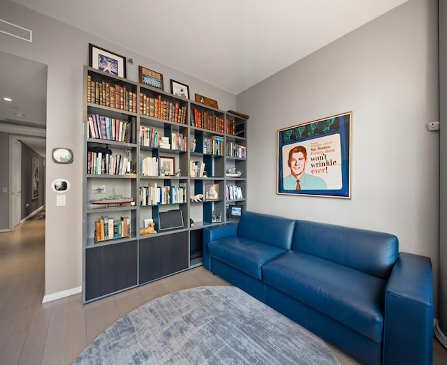 living area with wood finished floors, recessed lighting, visible vents, and baseboards