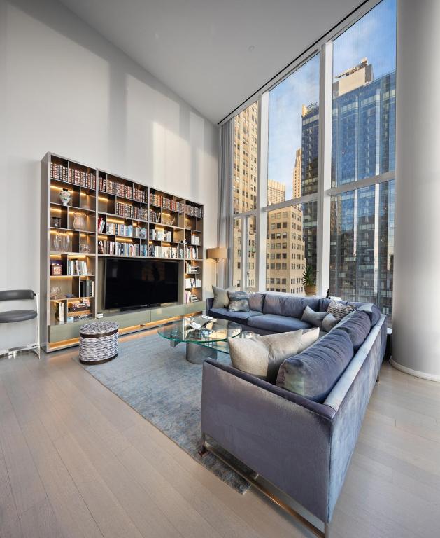 living room featuring hardwood / wood-style flooring, a wall of windows, and a high ceiling