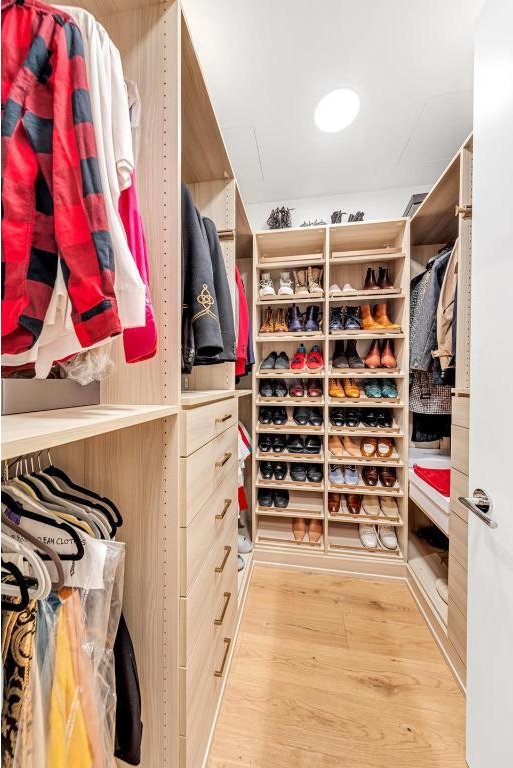 walk in closet with light wood-type flooring