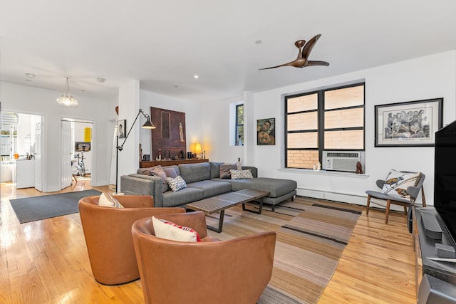 living area featuring ceiling fan, light wood finished floors, and cooling unit