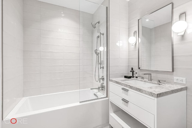 bathroom with tiled shower / bath combo and vanity