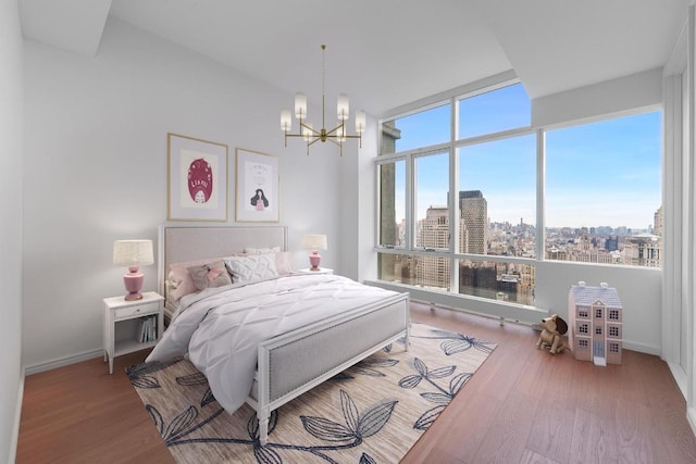 bedroom featuring wood-type flooring, a chandelier, and multiple windows