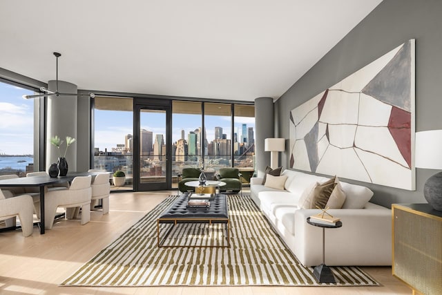 living room with floor to ceiling windows, a view of city, and wood finished floors