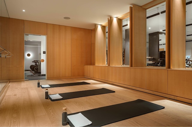 workout room with wood walls and wood finished floors