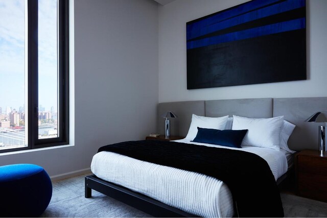 bedroom featuring baseboards and a view of city