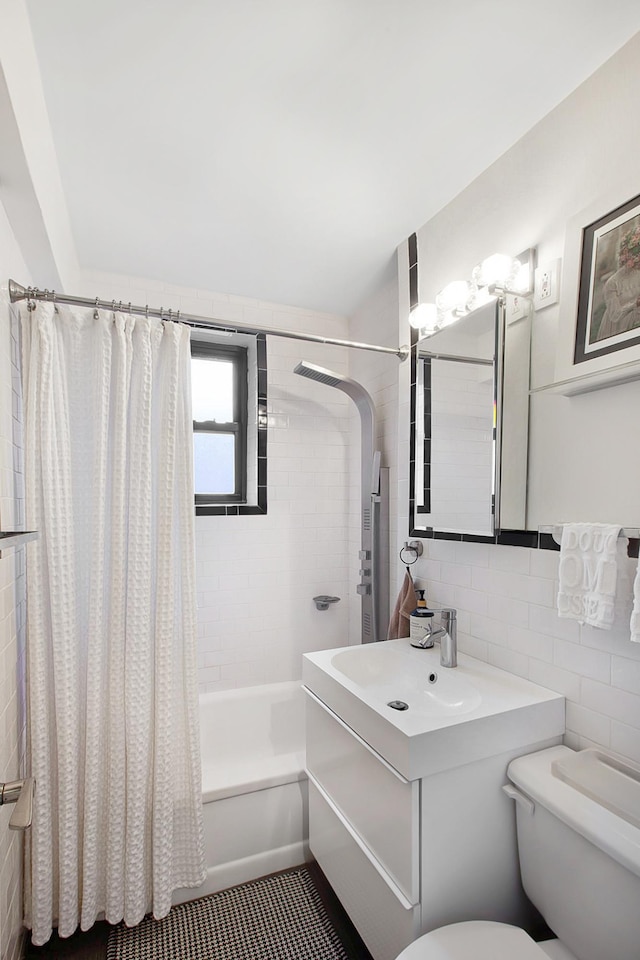 bathroom with tasteful backsplash, toilet, shower / tub combo with curtain, vanity, and tile walls