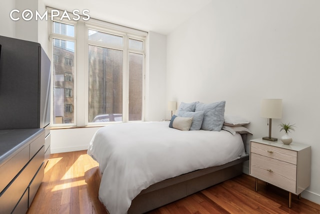 bedroom with baseboards and wood finished floors