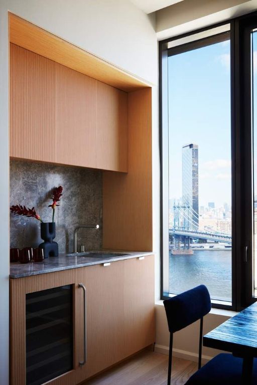 kitchen featuring sink, a water view, beverage cooler, light hardwood / wood-style floors, and decorative backsplash