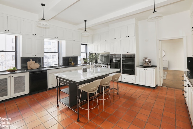 kitchen with dark countertops, black dishwasher, white cabinets, and beamed ceiling