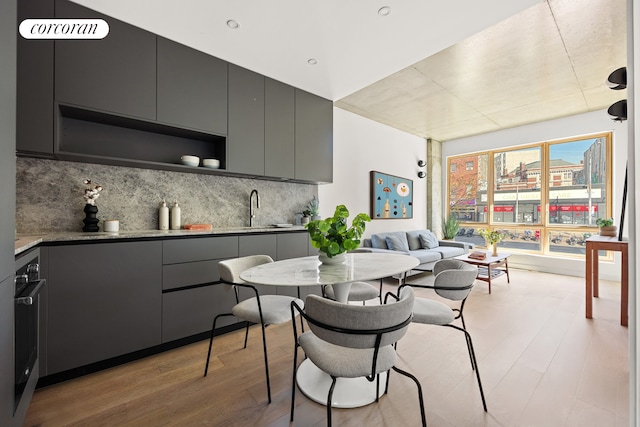 kitchen with open shelves, light wood-style floors, decorative backsplash, and gray cabinetry