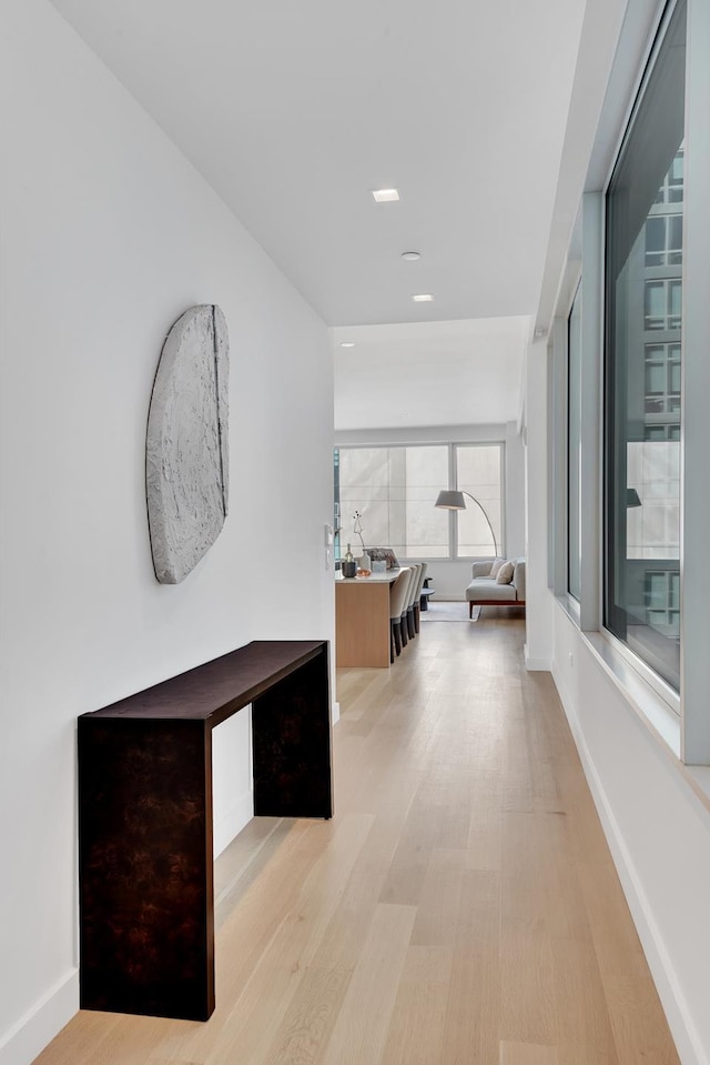 hall with wood finished floors, baseboards, and recessed lighting