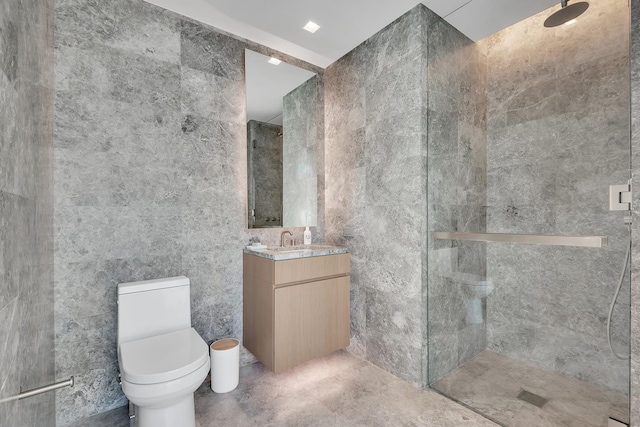 bathroom with tile walls, a tile shower, toilet, and vanity