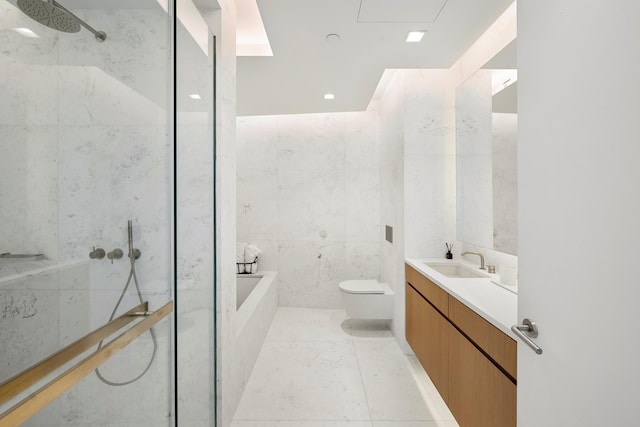 bathroom with toilet, tile walls, vanity, a garden tub, and a shower