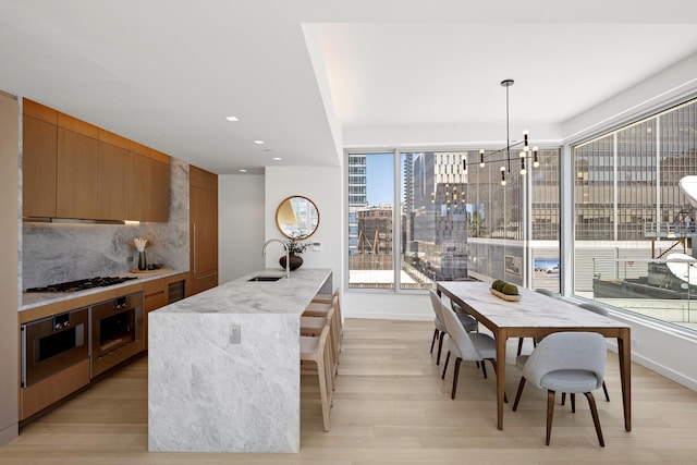 dining space featuring light wood-type flooring, a chandelier, recessed lighting, and baseboards
