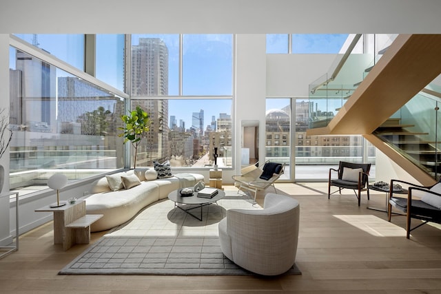 living area featuring a view of skyline, wood finished floors, plenty of natural light, and stairway