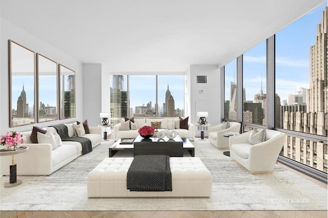 living room with a wall of windows, a wealth of natural light, and light hardwood / wood-style floors