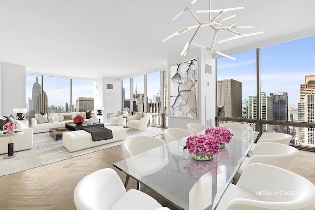 dining space with a notable chandelier, a healthy amount of sunlight, expansive windows, and parquet flooring