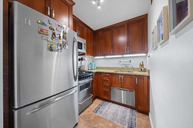 kitchen with light stone countertops, appliances with stainless steel finishes, and sink