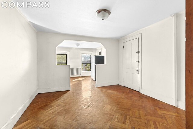 foyer with parquet flooring and radiator heating unit