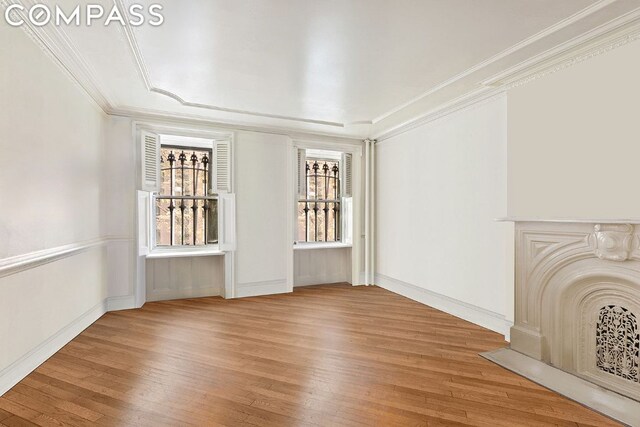 unfurnished living room featuring ornamental molding and wood-type flooring