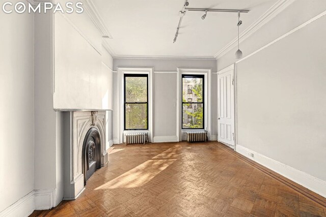 unfurnished living room featuring crown molding, parquet flooring, radiator heating unit, and rail lighting