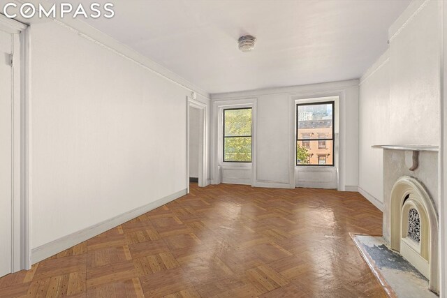 unfurnished living room featuring parquet floors and crown molding