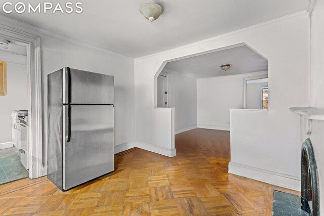 kitchen featuring light parquet flooring, stainless steel refrigerator, and ornamental molding