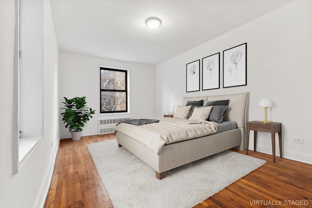 bedroom with light wood-type flooring, radiator, and baseboards