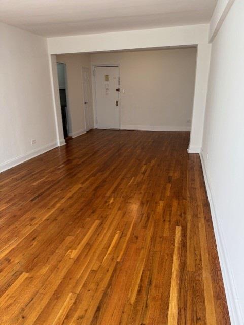 empty room featuring dark wood-style flooring and baseboards