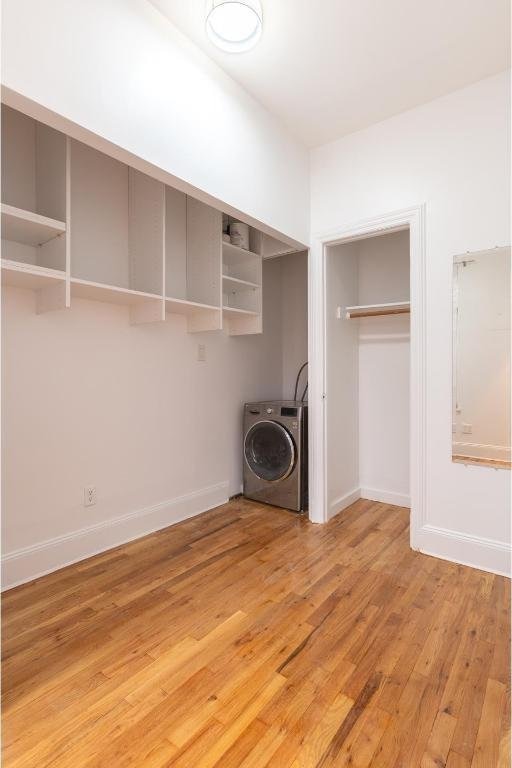 laundry room featuring wood-type flooring and washer / dryer