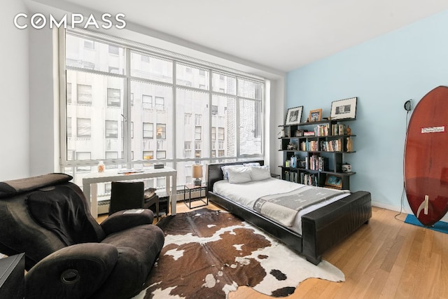 bedroom featuring baseboard heating and light wood-type flooring