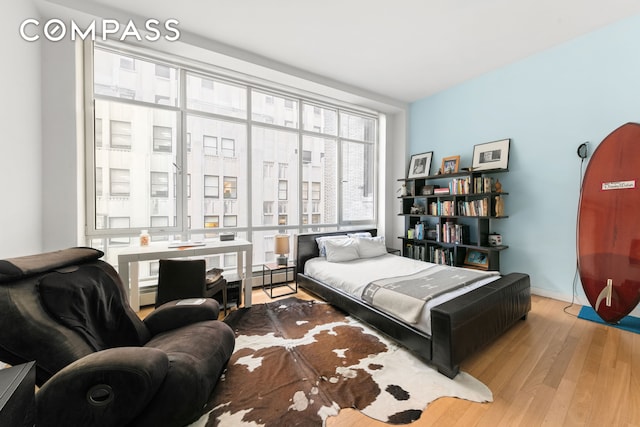 bedroom featuring baseboards, baseboard heating, and wood finished floors