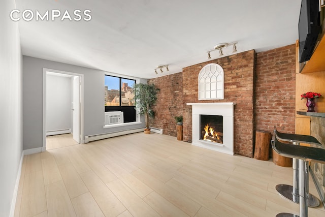 unfurnished living room featuring baseboard heating, wood finished floors, a lit fireplace, and a baseboard radiator