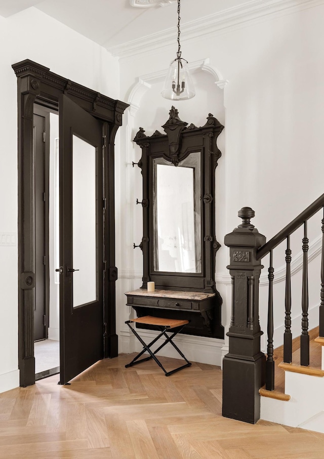 foyer entrance featuring stairway and ornamental molding