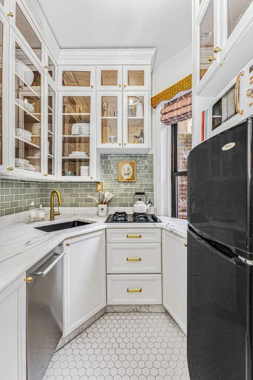 kitchen featuring appliances with stainless steel finishes, decorative backsplash, white cabinets, and sink