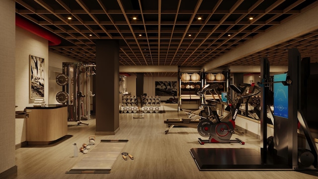 exercise room with baseboards and wood finished floors