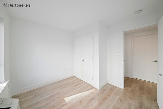 47-05 5th St Unit 203, New York City, NY 11101 - unfurnished bedroom with light wood-style floors, a closet, and baseboards