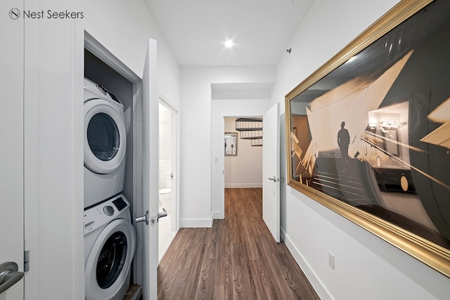 47-05 5th St Unit 203, New York City, NY 11101 - laundry room featuring stacked washing machine and dryer, dark wood-type flooring, and baseboards