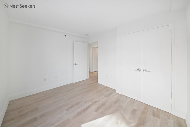 47-05 5th St Unit 203, New York City, NY 11101 - unfurnished bedroom featuring light wood finished floors, a closet, and baseboards