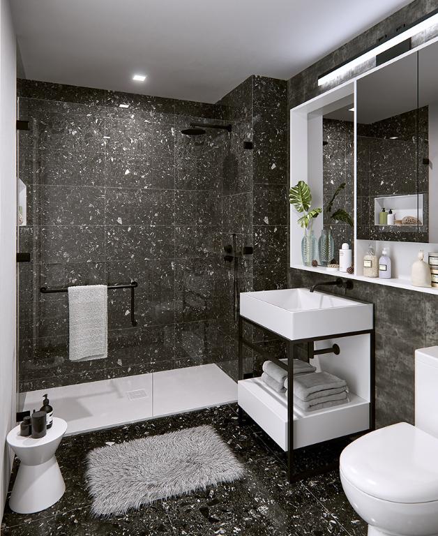 bathroom with a tile shower, sink, tile walls, and toilet