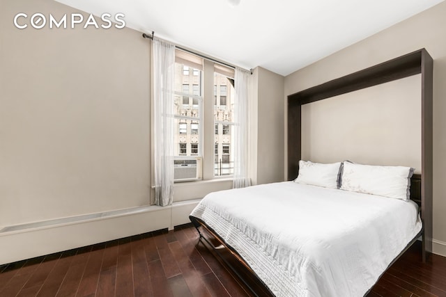 bedroom featuring multiple windows and wood finished floors