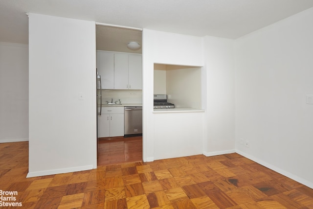 kitchen with baseboards, a sink, stainless steel appliances, light countertops, and white cabinets