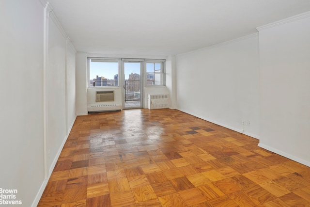 spare room with ornamental molding, radiator, and light parquet floors