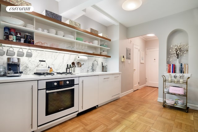 kitchen featuring white gas cooktop, light parquet floors, oven, decorative backsplash, and white cabinets