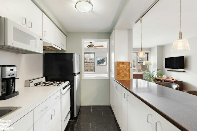 kitchen with white appliances, ceiling fan, hanging light fixtures, white cabinets, and under cabinet range hood