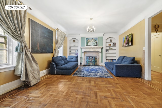 living area with built in shelves, baseboards, a chandelier, and a fireplace